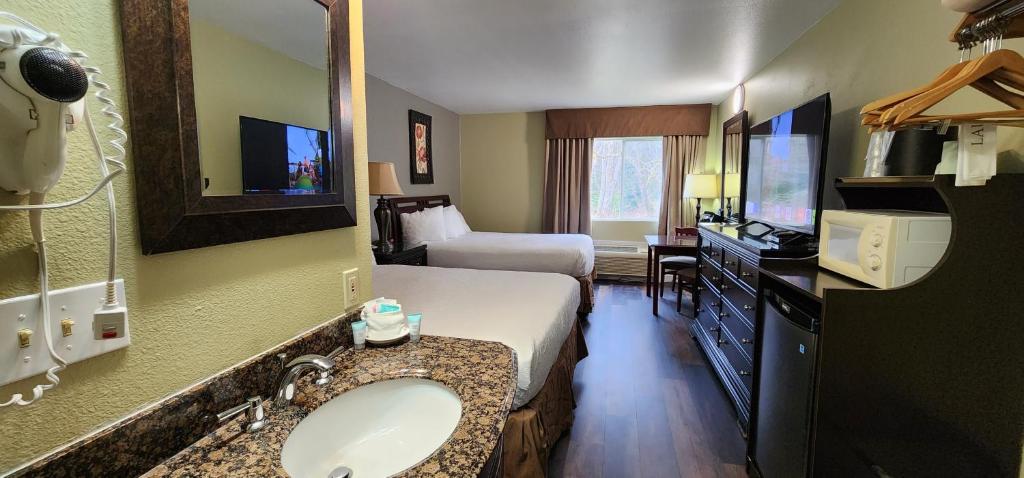 a hotel room with a bathroom with a bed and a sink at Crest Trail Lodge in Packwood