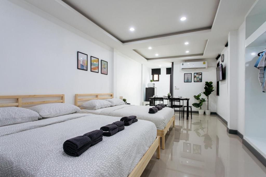 three beds in a room with white walls at P3 Silom Large 2beds full kitchen WIFI 4-6pax in Bangkok