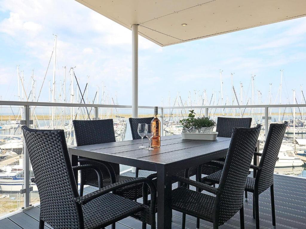einen Tisch mit Stühlen und eine Flasche Wein auf dem Balkon in der Unterkunft Apartment Wendtorf XXVIII in Wendtorf