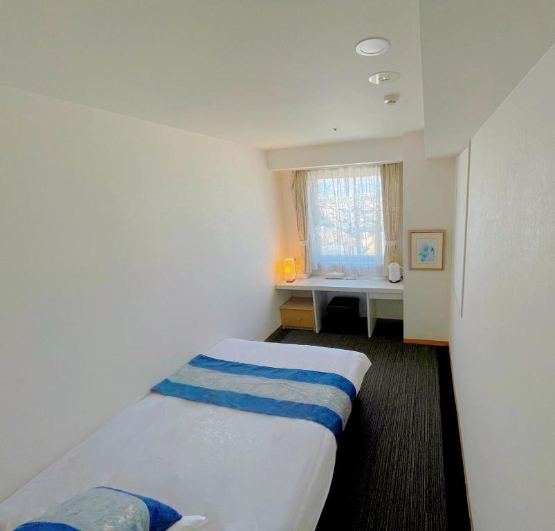 ein Hotelzimmer mit einem Bett und einem Fenster in der Unterkunft Hotel KOYO Bekkan - Vacation STAY 29013v in Hashima