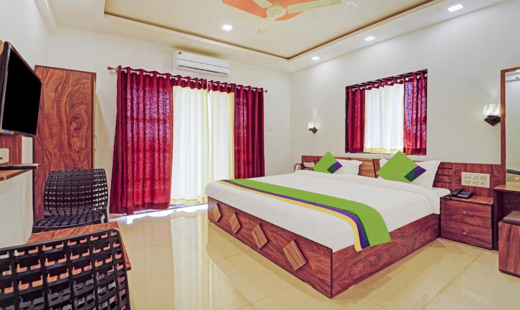 um quarto com uma cama grande e uma televisão em Treebo Trend Infinity View Mahabaleswar em Mahabaleshwar