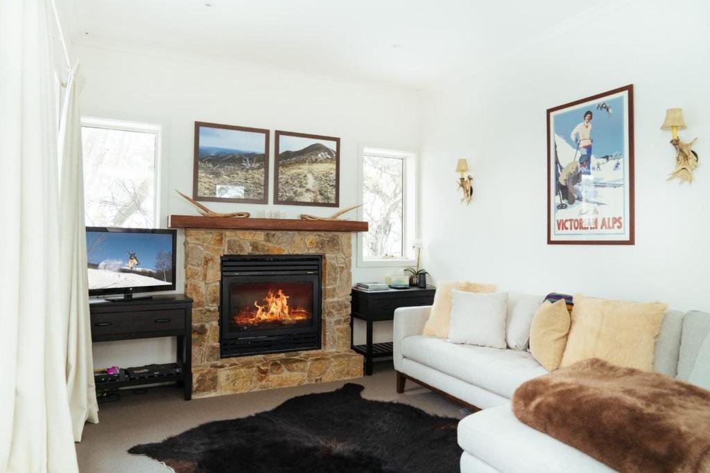 a living room with a couch and a fireplace at Reindeer 6 in Mount Buller