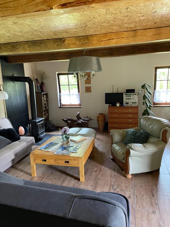 een woonkamer met een bank en een salontafel bij Dom nad rzeką in Neple
