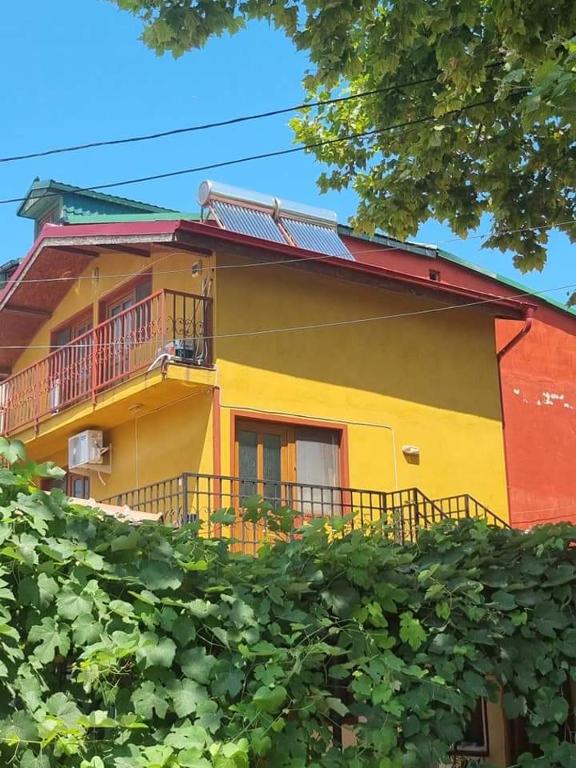 a yellow and red house with a balcony at Vila Ioana & Mirel in Eforie Sud
