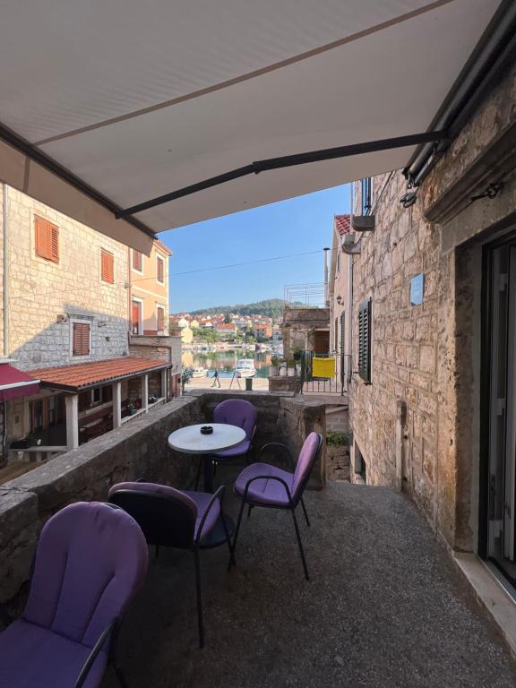a patio with purple chairs and a table on a balcony at Residence Bella in Stari Grad