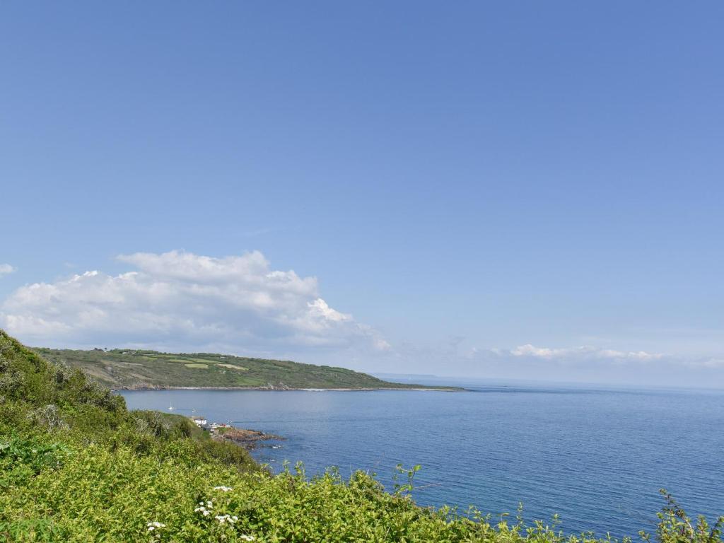 a view of a large body of water from a hill at Headlands Hideaway in Coverack