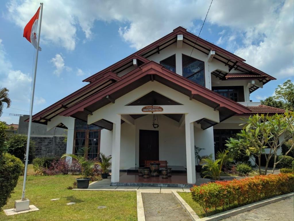 a house with a flag in front of it at Omah Pelem Yogya in Yogyakarta