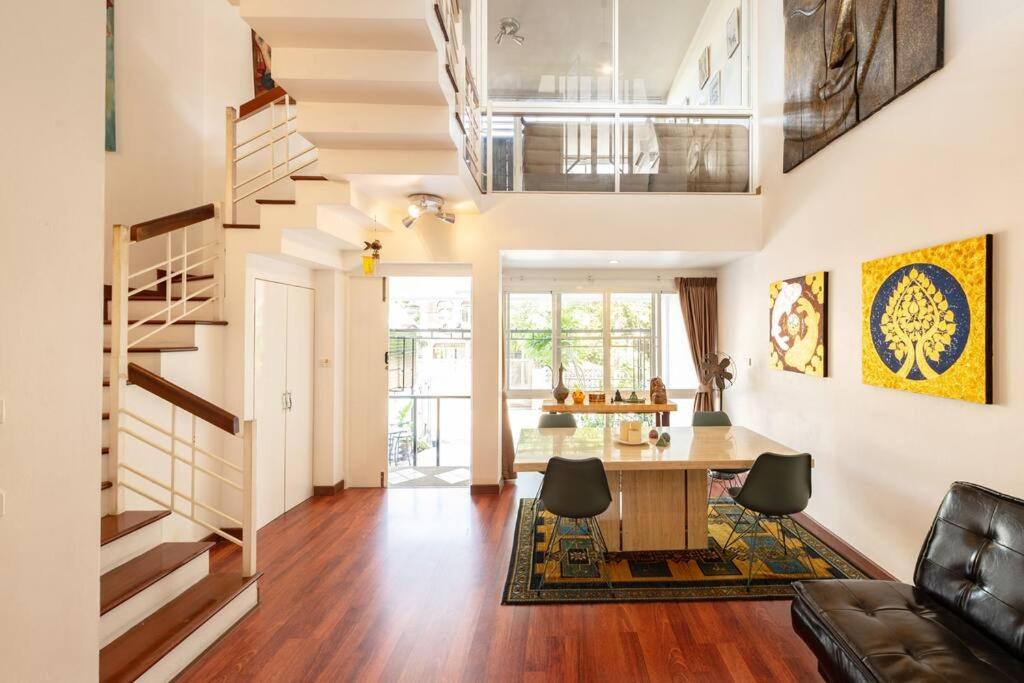 a living room with a dining room table and a staircase at 420 House- up to 10 guests in central Bangkok. in Bangkok