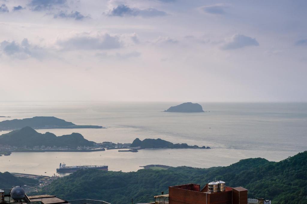a view of a large body of water with mountains at H&amp; Jiufen The Dragon Inn in Jiufen
