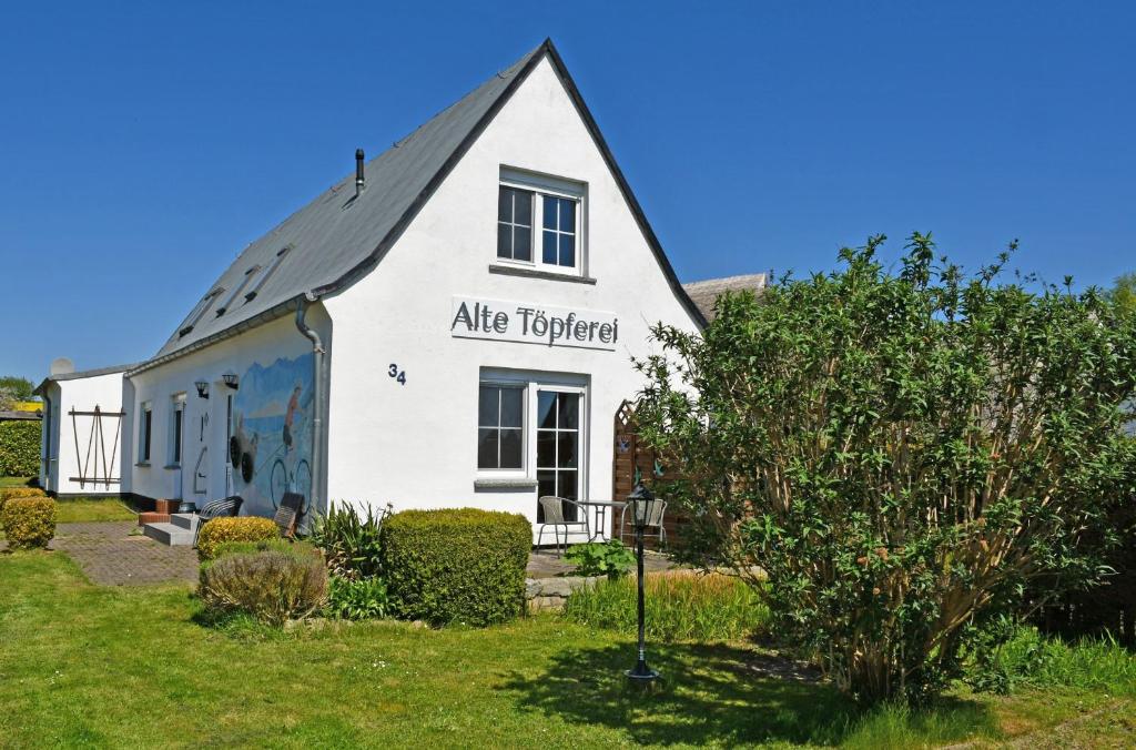 Una casa blanca con un cartel en el costado. en Ferienhaus mit Boddenblick, en Middelhagen