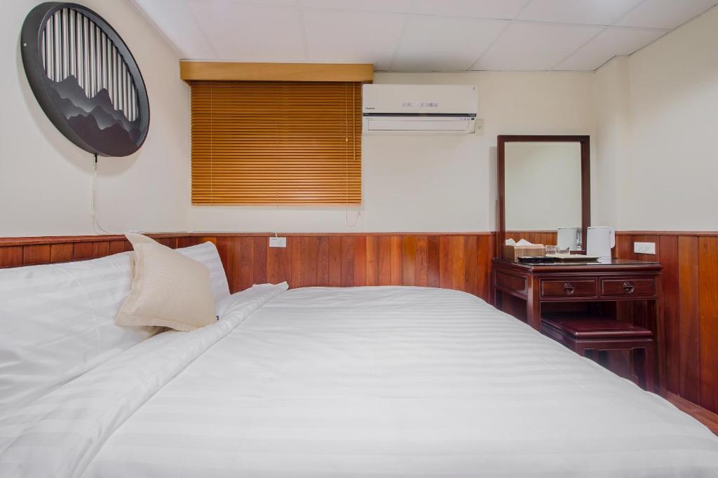 a bedroom with a large white bed and a desk at H&amp; Jiufen The Dragon Inn in Jiufen