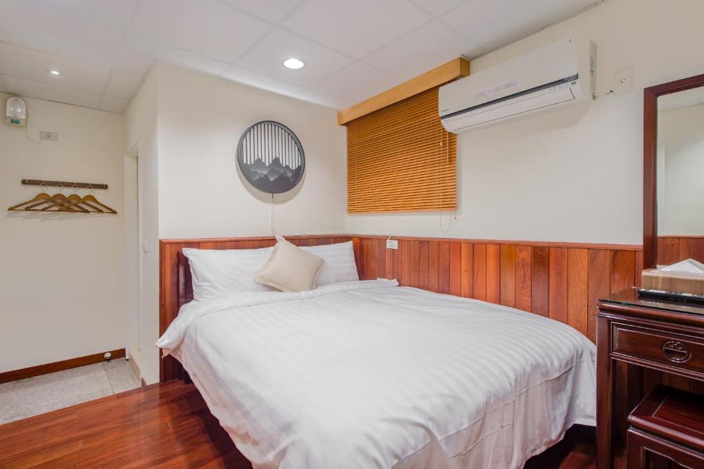 a bedroom with a large white bed and a window at H&amp; Jiufen The Dragon Inn in Jiufen