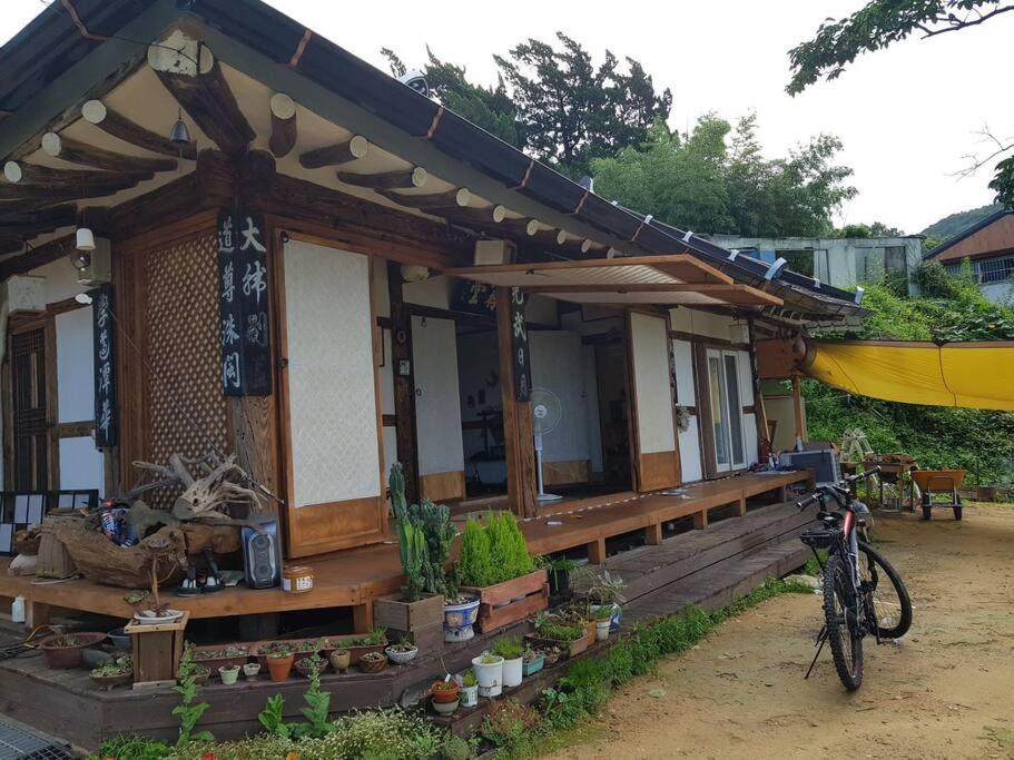 Gugangjae Hanok Stay في جيونجو: منزل به دراجة متوقفة أمامه