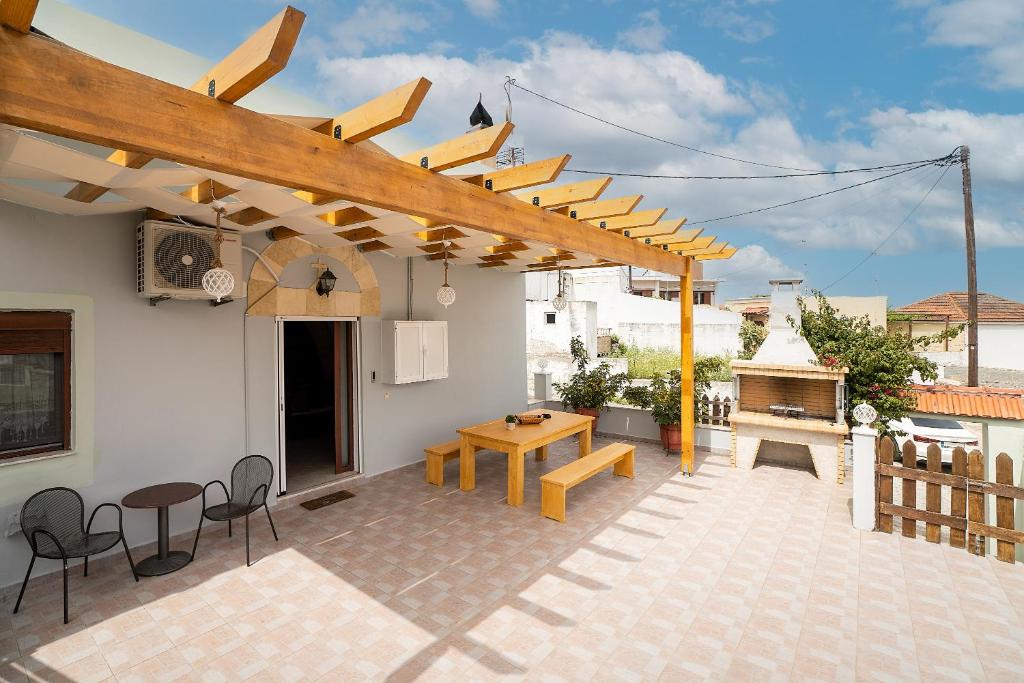 a patio with a table and a wooden pergola at Villa Nikolaos in Fánai