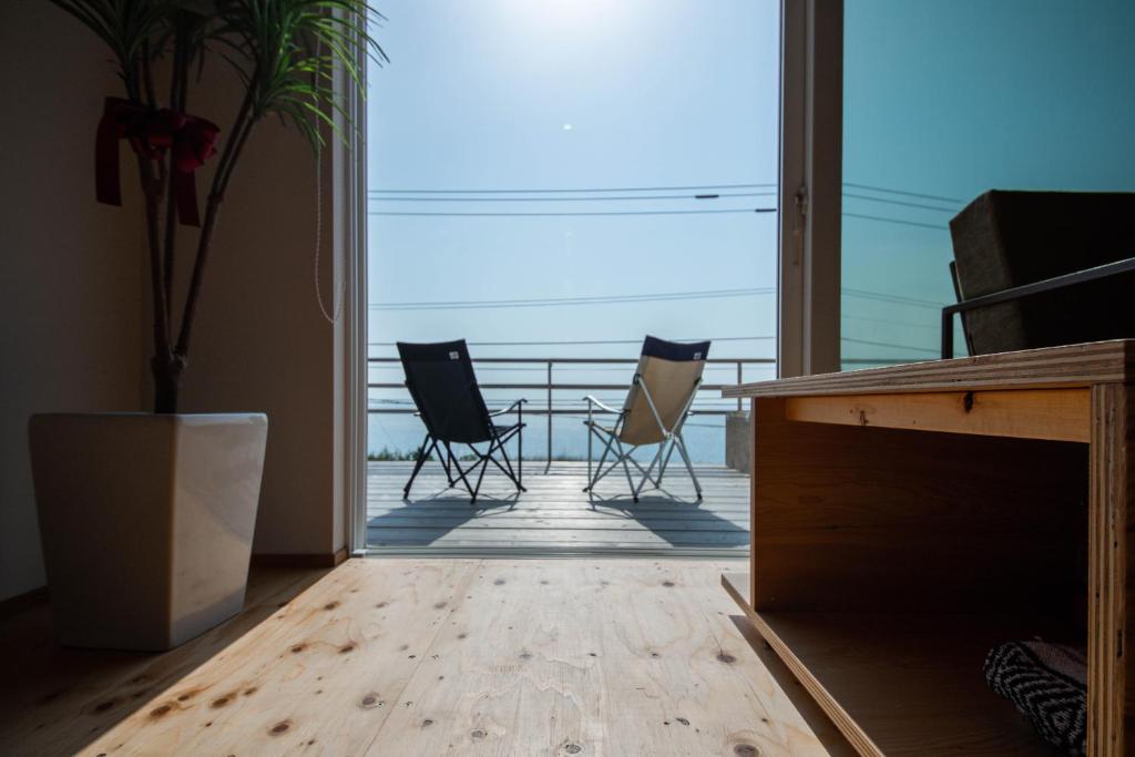 una camera con due sedie e un tavolo sul balcone di Sunny SIDE HOUSE 