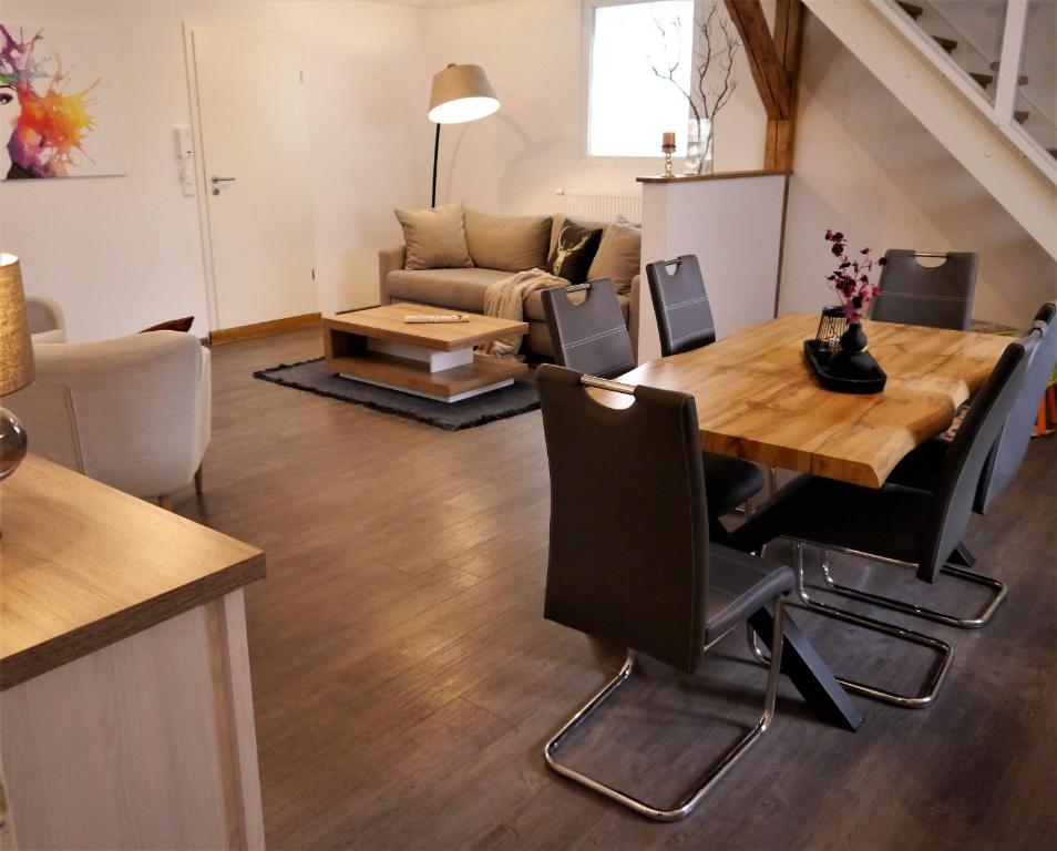 - un salon avec une table et un canapé dans l'établissement FeWo Fuchsbau mit Dampfdusche und Kamin, à Bad Harzburg