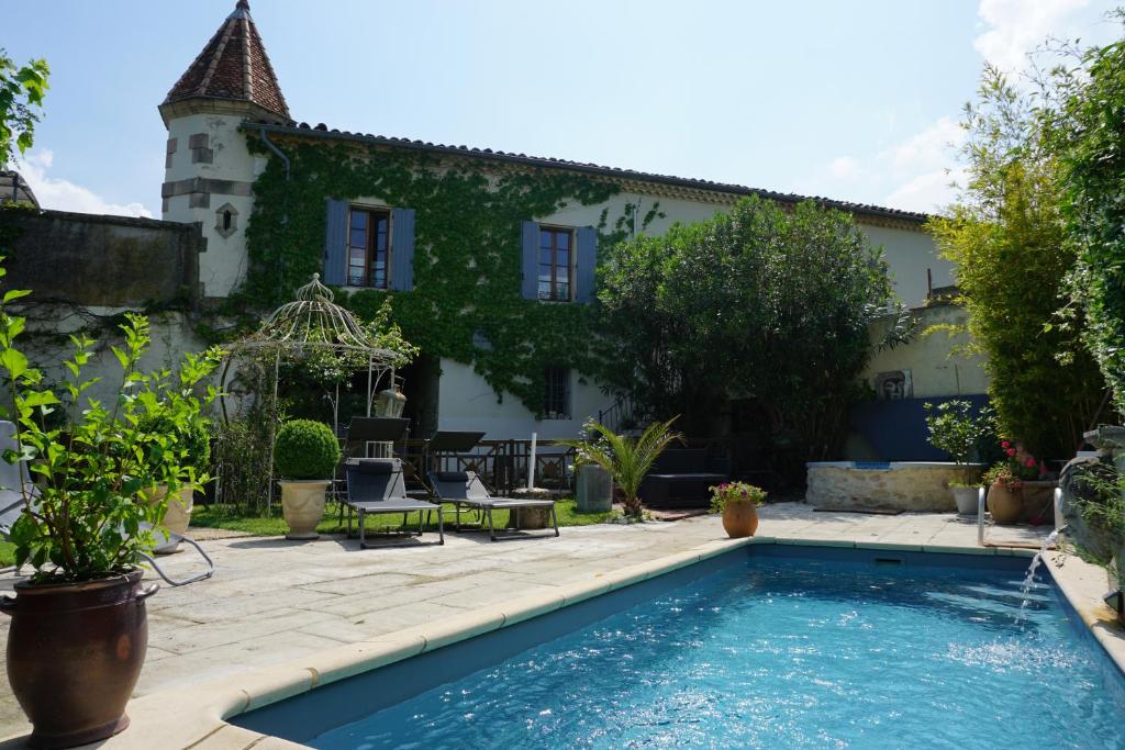 a house with a swimming pool in front of a building at Les Deux Tours in Brignon