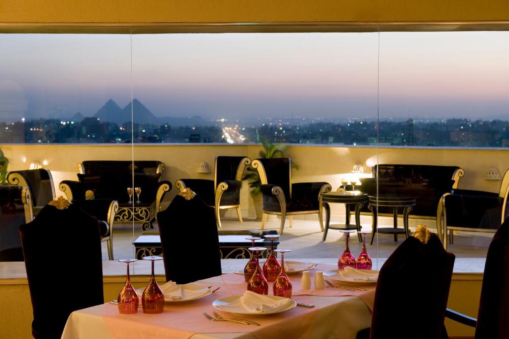 un restaurante con mesas y sillas y una gran ventana en Barceló Cairo Pyramids, en El Cairo