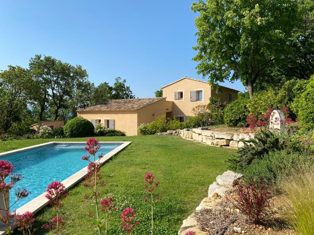a yard with a swimming pool in front of a house at Chante Coucou in Saint-Saturnin-lès-Apt