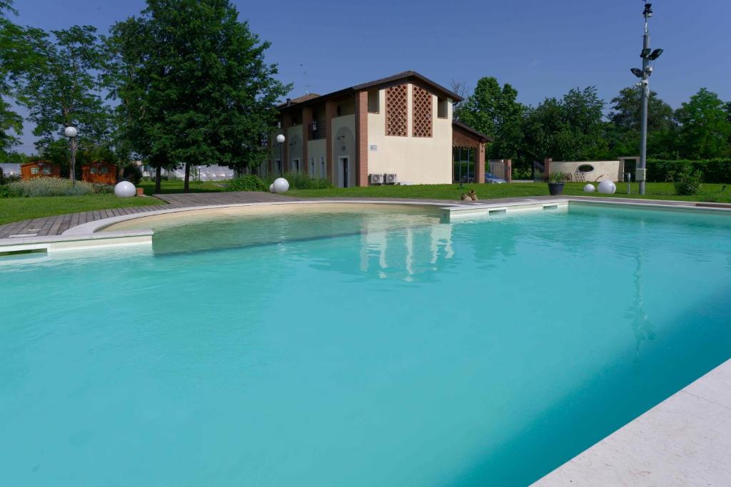 a large swimming pool in front of a building at Agriturismo La Boschina in Crema