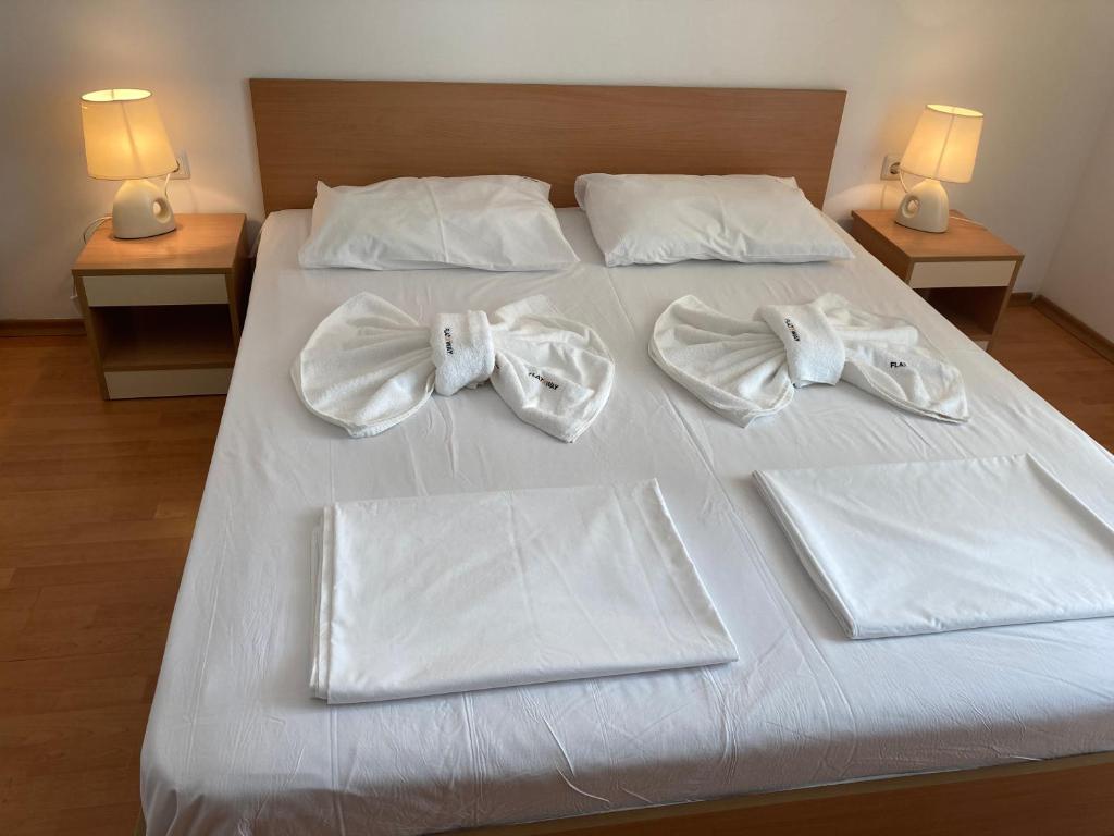 a bed with white towels and bow ties on it at YASSEN in Sunny Beach