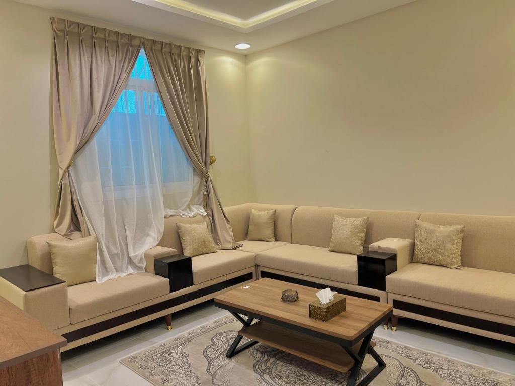 a living room with a couch and a coffee table at السلطان للشقق المفروشة in AlUla