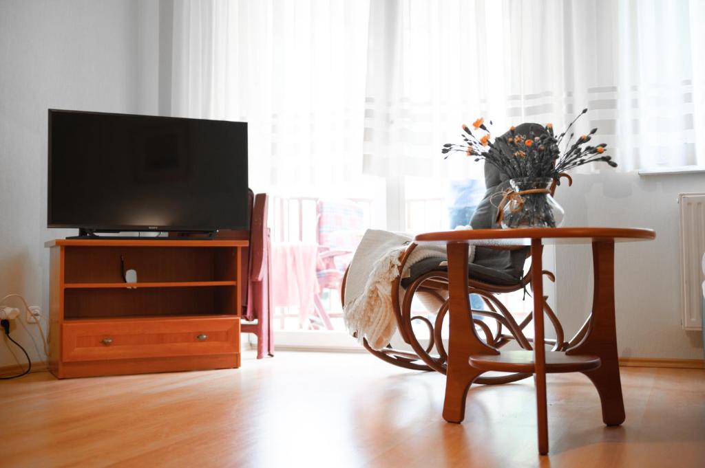 a living room with a chair and a table and a tv at Grunwaldzka 104 in Pobierowo