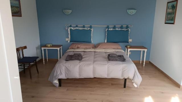 1 dormitorio azul con 1 cama grande y 2 mesas en Stellaria casa vacanze in montagna panorama stupendo Sardegna en Seùlo