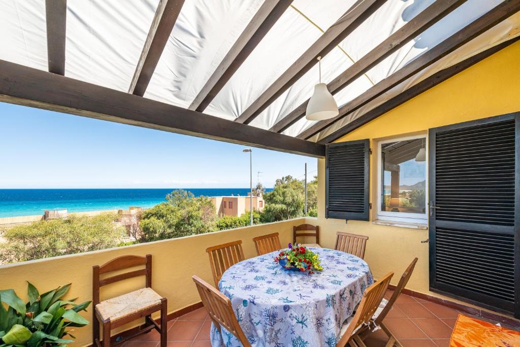 a patio with a table and chairs and the ocean at Seb beach in Costa Rei
