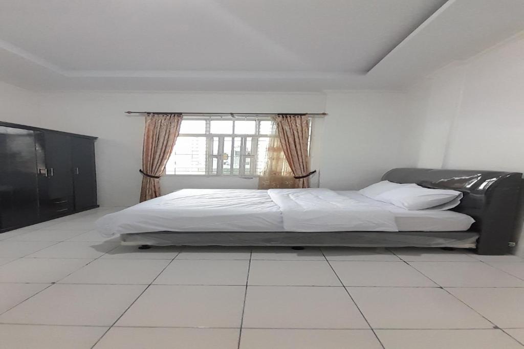 1 dormitorio con 1 cama y ventana en una habitación en OYO 92578 Sri Ulina Homestay, en Medan