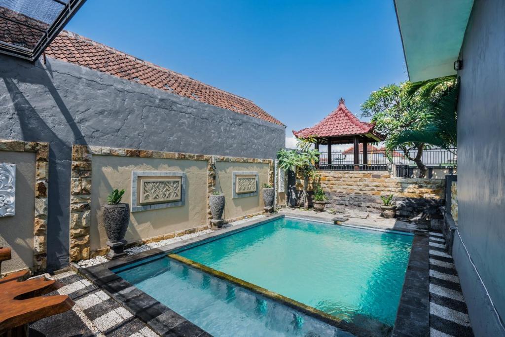 a swimming pool next to a building with a house at The Lavana Villa M Seririt in Bubunan