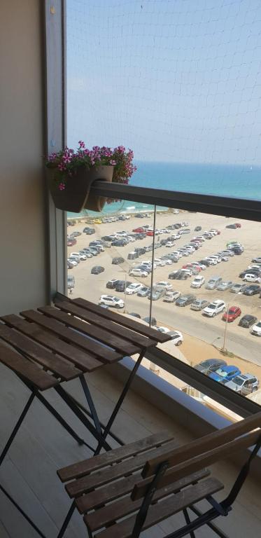 um banco num quarto com vista para um parque de estacionamento em Mandarin hotel beach view em Jaffa-Tel Aviv