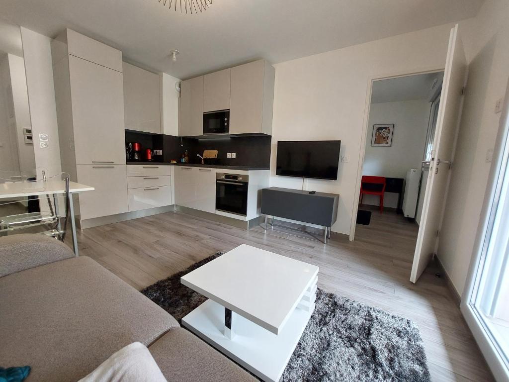 sala de estar con sofá y mesa en Appartement sur Valberg dans résidence neuve proche centre en Valberg