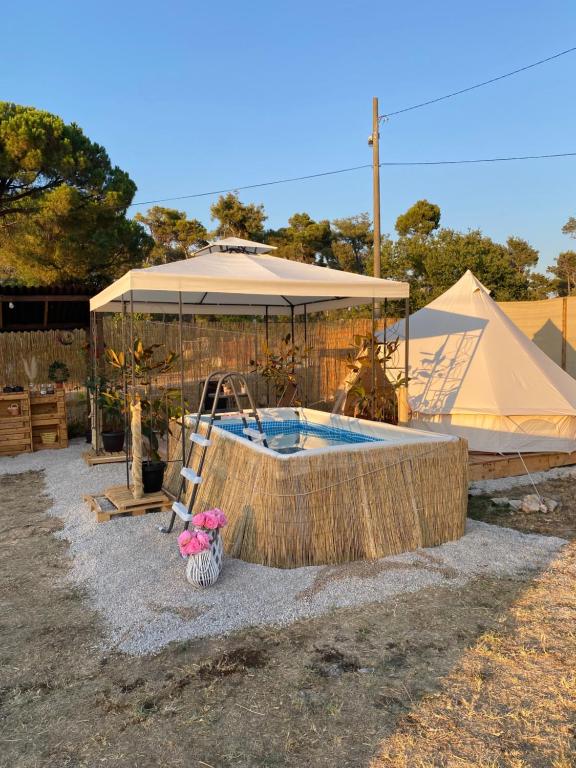 uma piscina com um guarda-sol e uma tenda em Estera Tent em Grgomičić