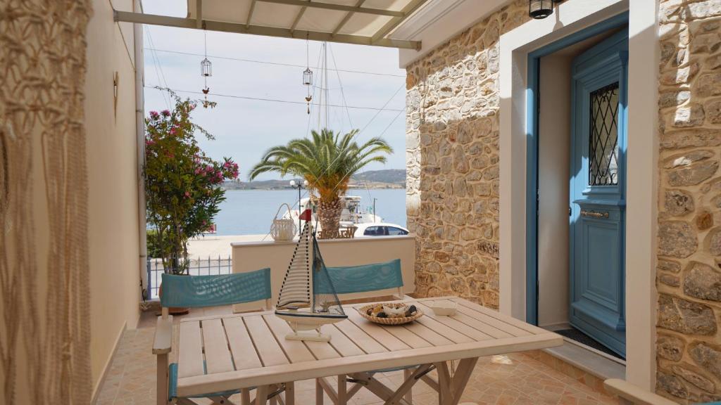 a table and chairs on a balcony with a view of the water at Elli in Ermioni