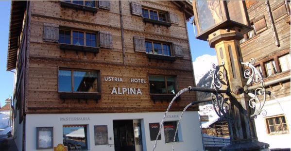 budynek na ulicy z kijem przed nim w obiekcie Familienhotel Alpina w mieście Breil/Brigels