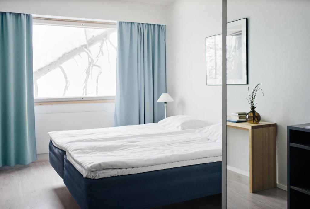 a bedroom with a bed and a window at Ski-Inn Hotel Pyhätunturi in Pyhätunturi