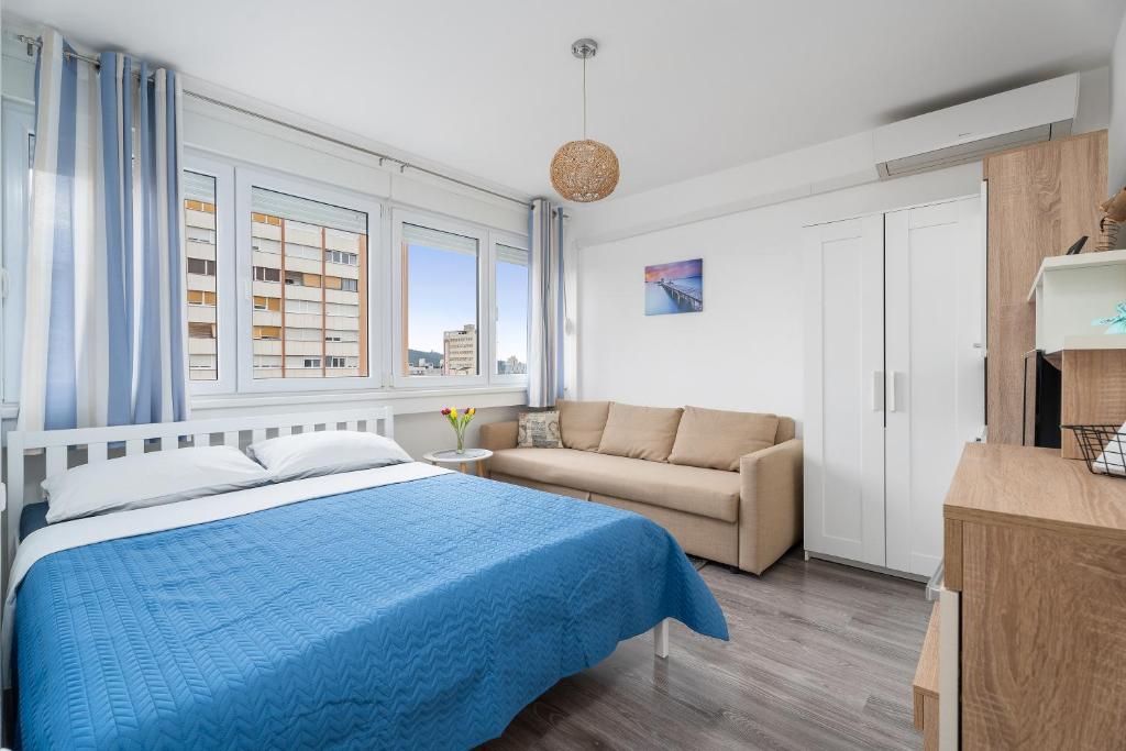 um quarto com uma cama azul e um sofá em Sunshine Split em Split