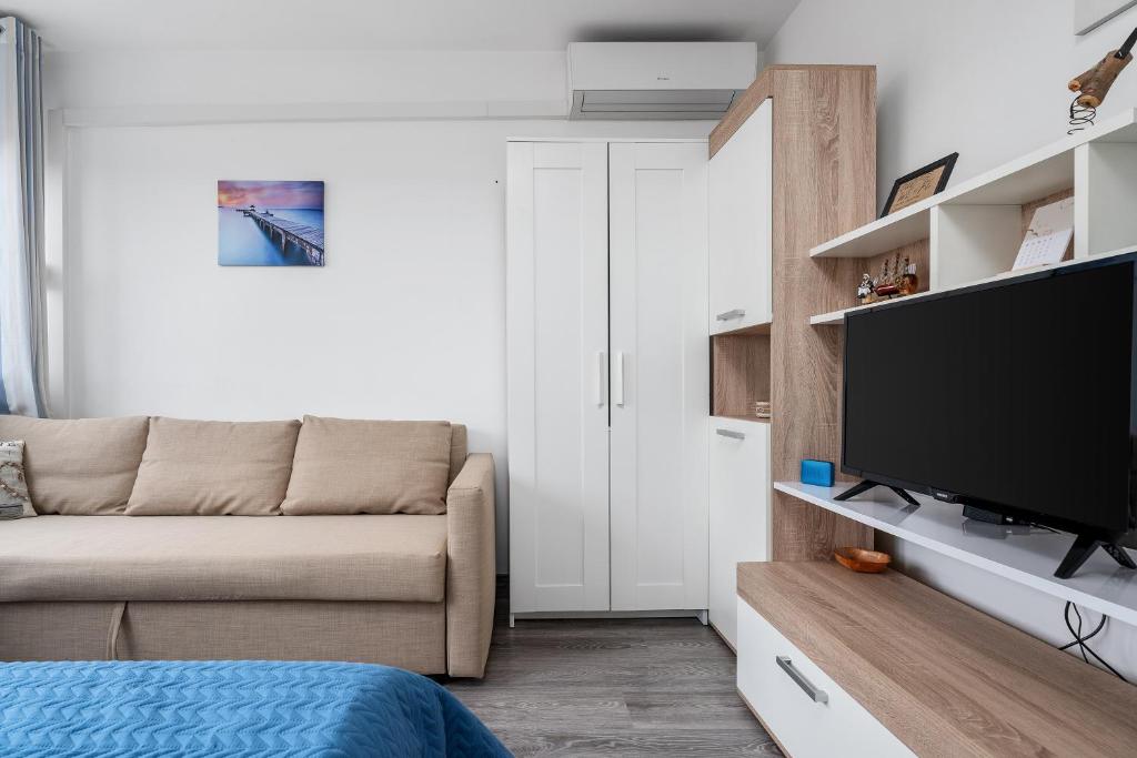 uma sala de estar com um sofá e uma televisão de ecrã plano em Sunshine Split em Split