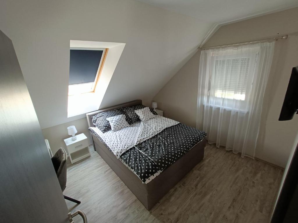 ein kleines Schlafzimmer mit einem Bett und einem Fenster in der Unterkunft Flower Apartman 5 