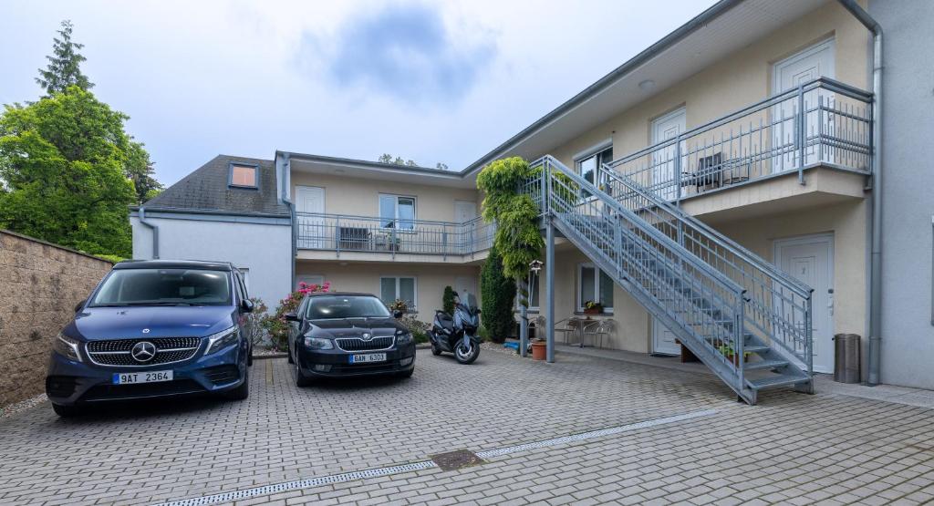 zwei Autos, die vor einem Haus geparkt sind in der Unterkunft Penzion Rodos - Café in Prag