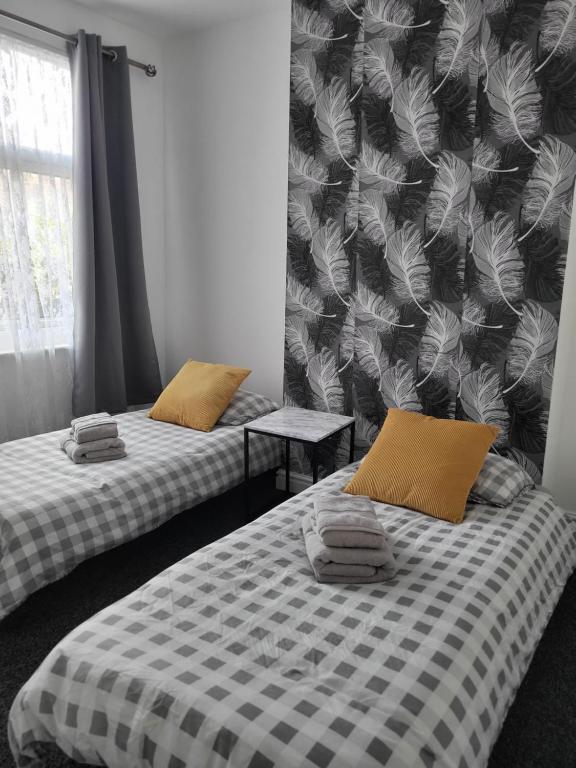 two beds in a room with a black and white patterned wall at House 36 in Liverpool