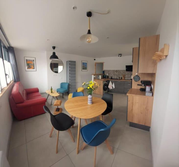 Il comprend un salon avec une table et des chaises ainsi qu'une cuisine. dans l'établissement Le Cormoran emplacement idéal, moderne très équipé, à Thury-Harcourt