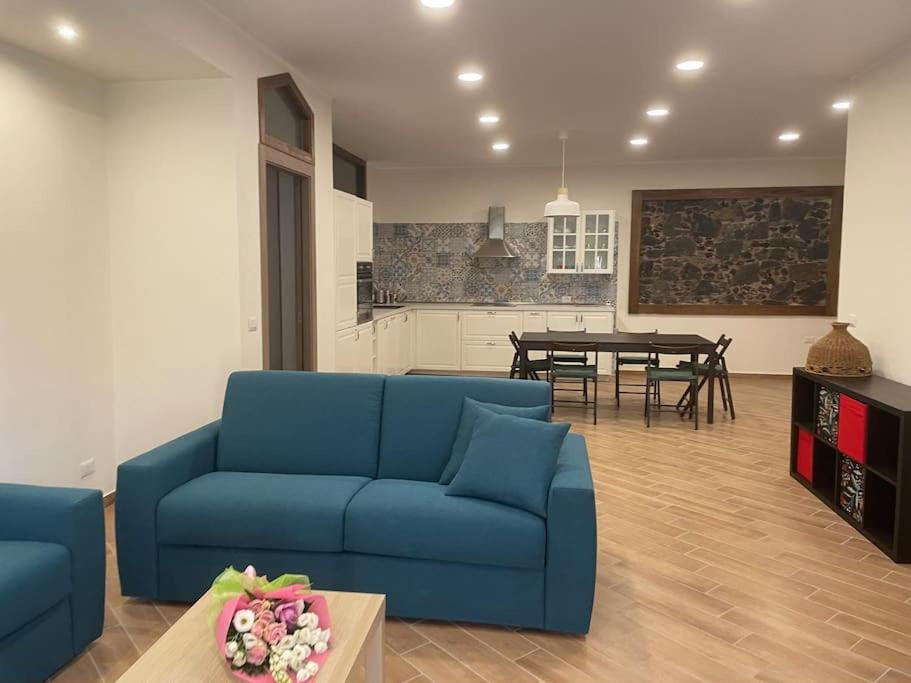 un soggiorno con divano blu e tavolo di Casa Pomelia a Mascali