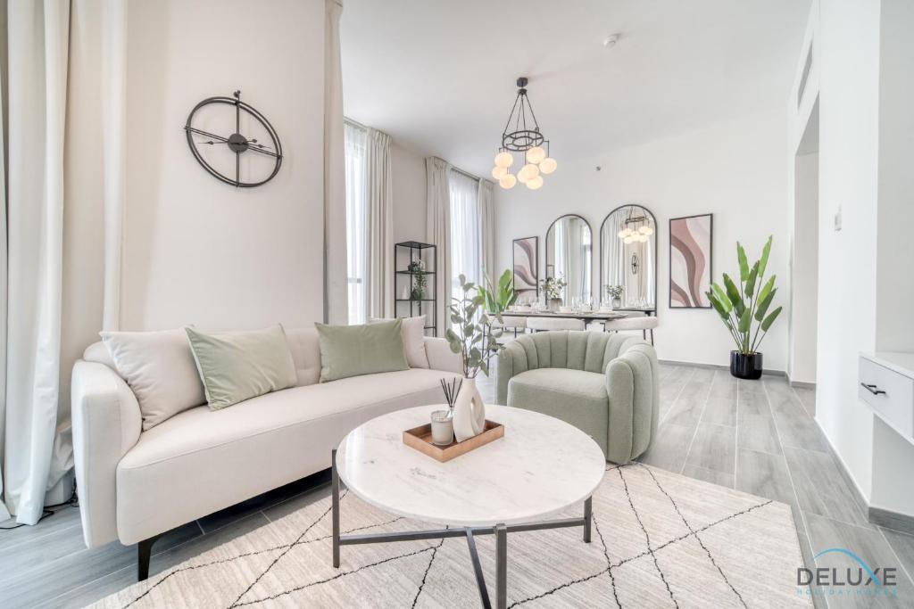 a living room with a white couch and a table at Suave 2BR with Assistant Room at Mesk 1 Midtown Dubai Production City by Deluxe Holiday Homes in Dubai