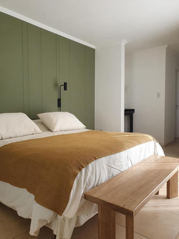 a bedroom with a large bed and a wooden bench at Premium appart LOCADOR Nueva Cordoba14C in Cordoba