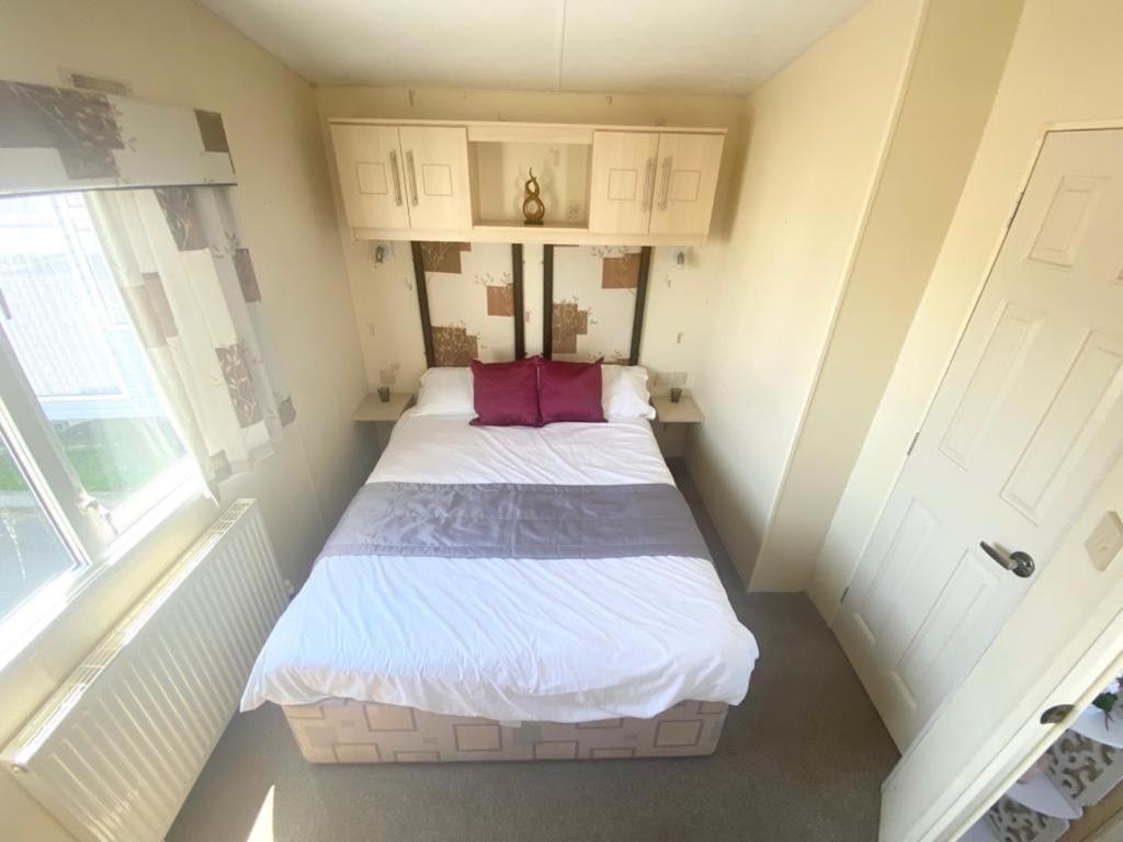 1 dormitorio pequeño con 1 cama en una habitación en Seaside Holiday Home St. Osyth, Essex 2 Bathroom, 6 Berth with Country Views en Saint Osyth