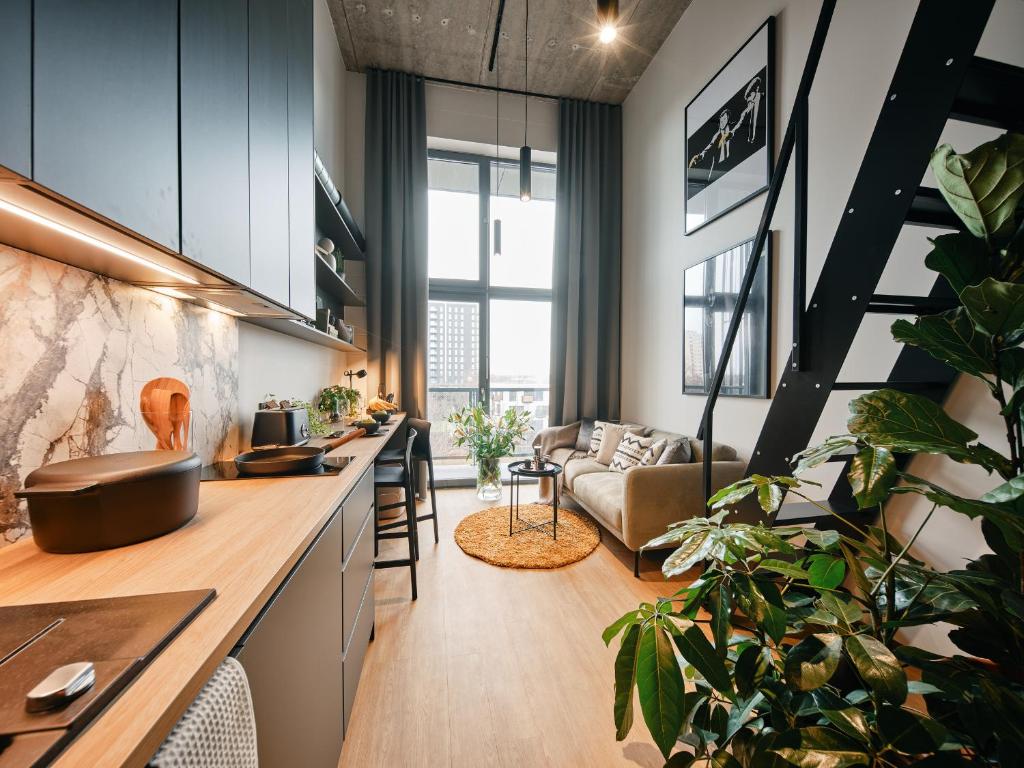 a kitchen and living room with a staircase and a couch at Rocca House by Larsen in Tallinn