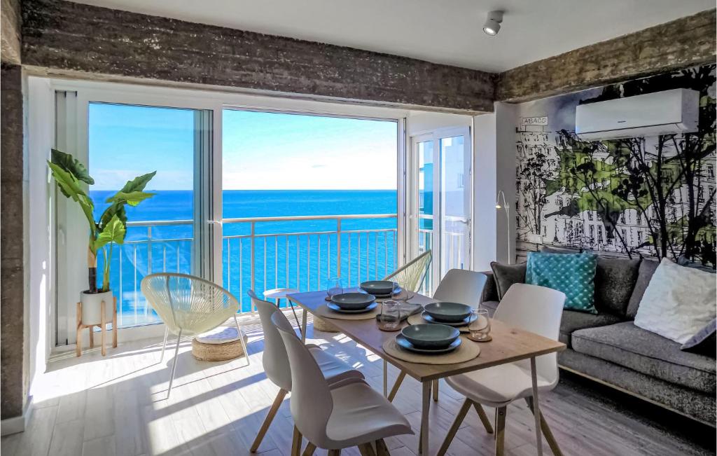 Sala de estar con mesa y vistas al océano en Cozy Apartment In Oropesa Del Mar With Outdoor Swimming Pool, en Oropesa del Mar