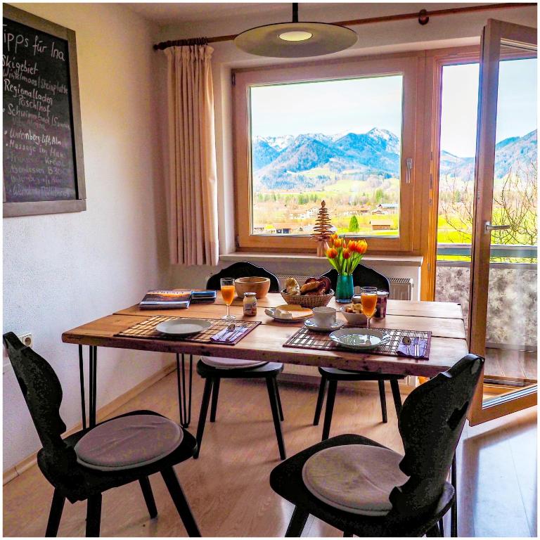 a dining room table with chairs and a large window at Wohnung Weitsicht Ruhpolding, 3 Schlafzimmer, Bergpanorama, Alleinlage in Ruhpolding